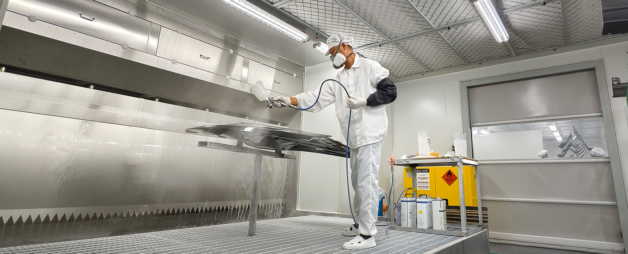 Staff members are applying paint to carbon fiber components.