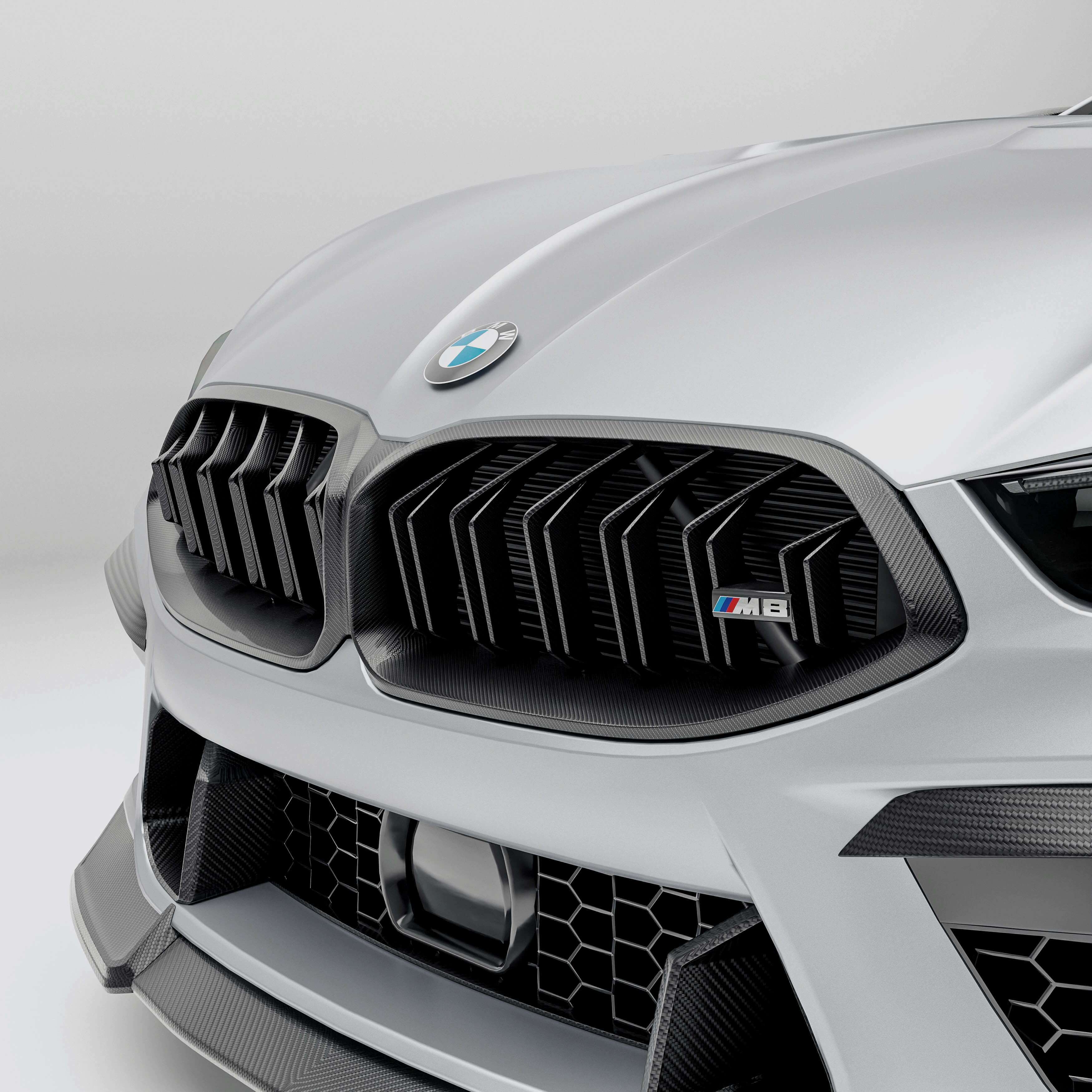 BMW M8 F92 with a carbon fiber grille front-angle on a white background