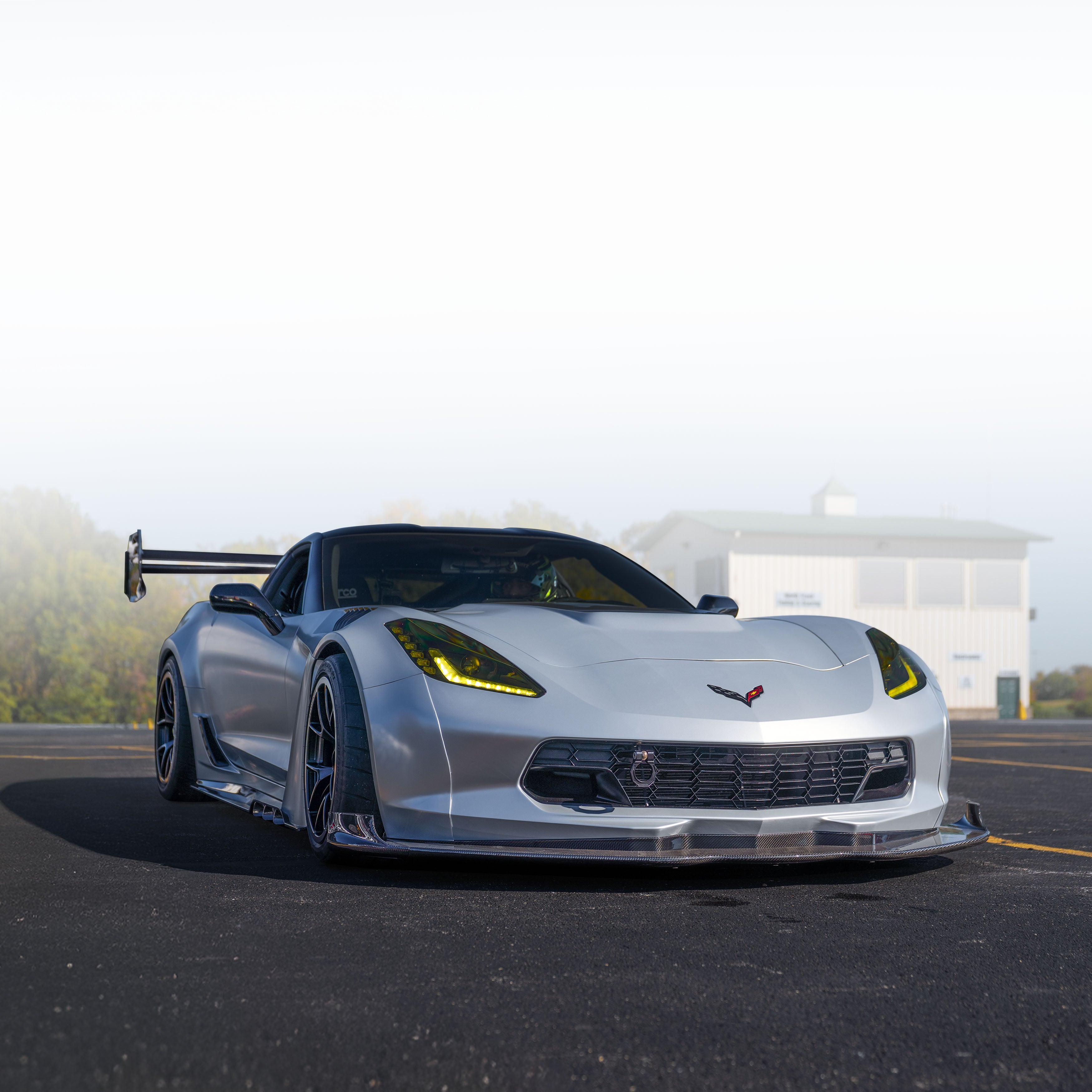 Silver sports car on a road with carbon fiber bodykit