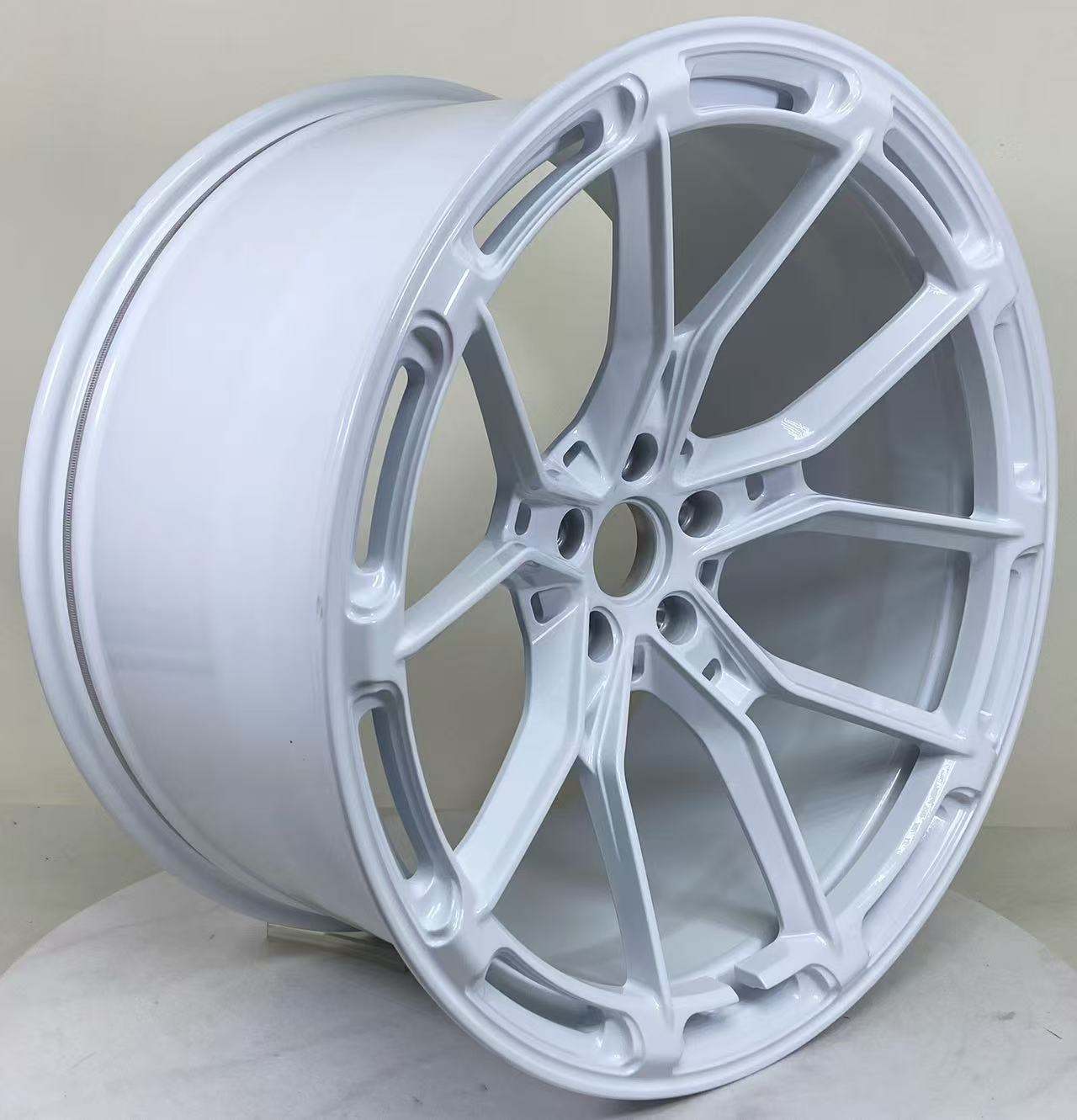 White REVOZPORT forged alloy wheel with lightweight split-spoke design displayed in a clean studio setting.