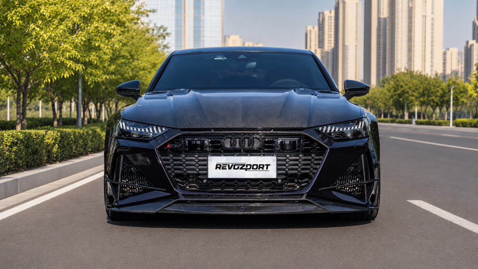 Black Audi RS7 featuring a REVOZPORT carbon fiber body kit with front lip, side skirts, carbon hood, and aggressive aero styling driving on a city street.