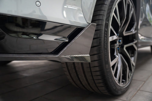 Hands-on carbon fiber diffuser installation highlighting precision fitment, detailed craftsmanship, and motorsport-inspired aero components inside a professional workshop environment.