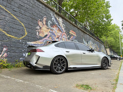 Silver Audi with carbon fiber body kit parked beside a graffiti wall, highlighting rear diffuser, side skirts, and sporty stance.
