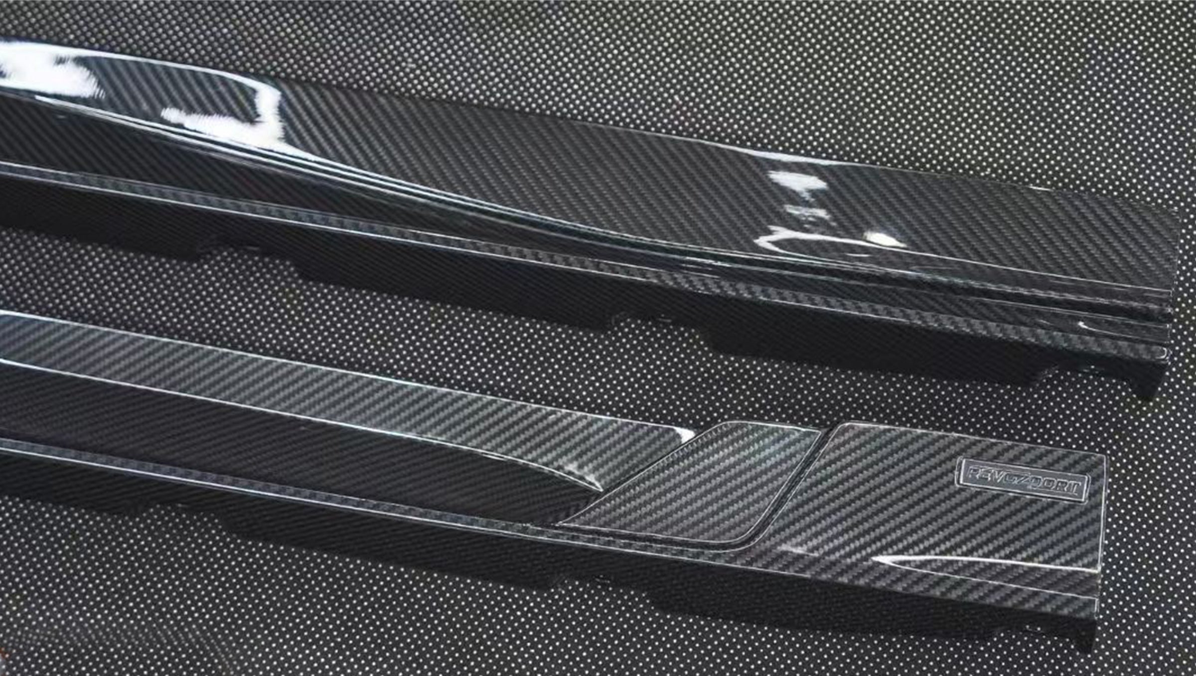REVOZPORT glossy carbon fiber body kit components displayed before installation, including front lip sections, side skirts, rear diffuser, and aero trim pieces.