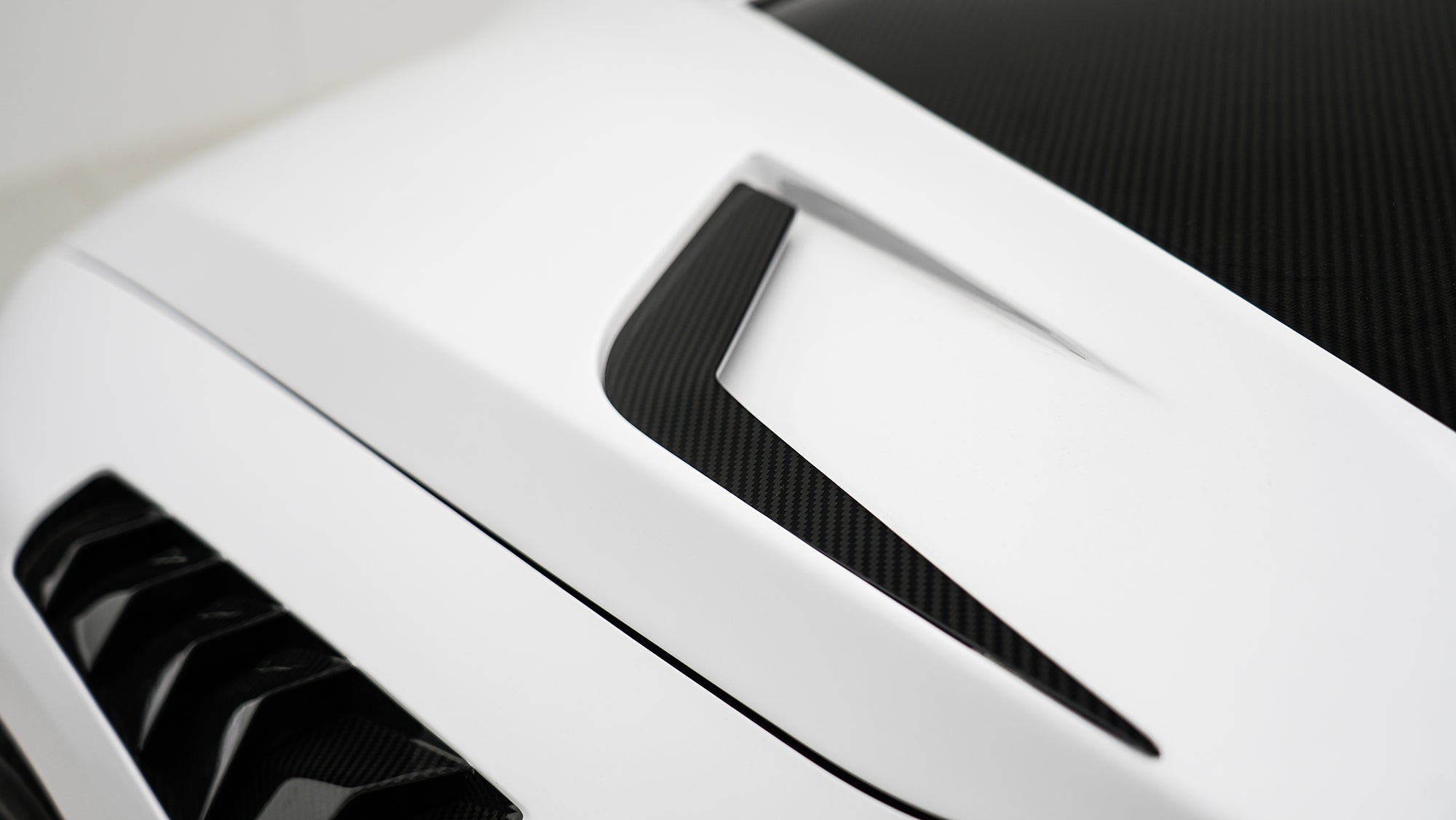 White BMW G80 M3 featuring a REVOZPORT carbon fiber body kit with front lip, side skirts, canards, vented fenders, and yellow DRL headlights displayed in a clean studio setting.