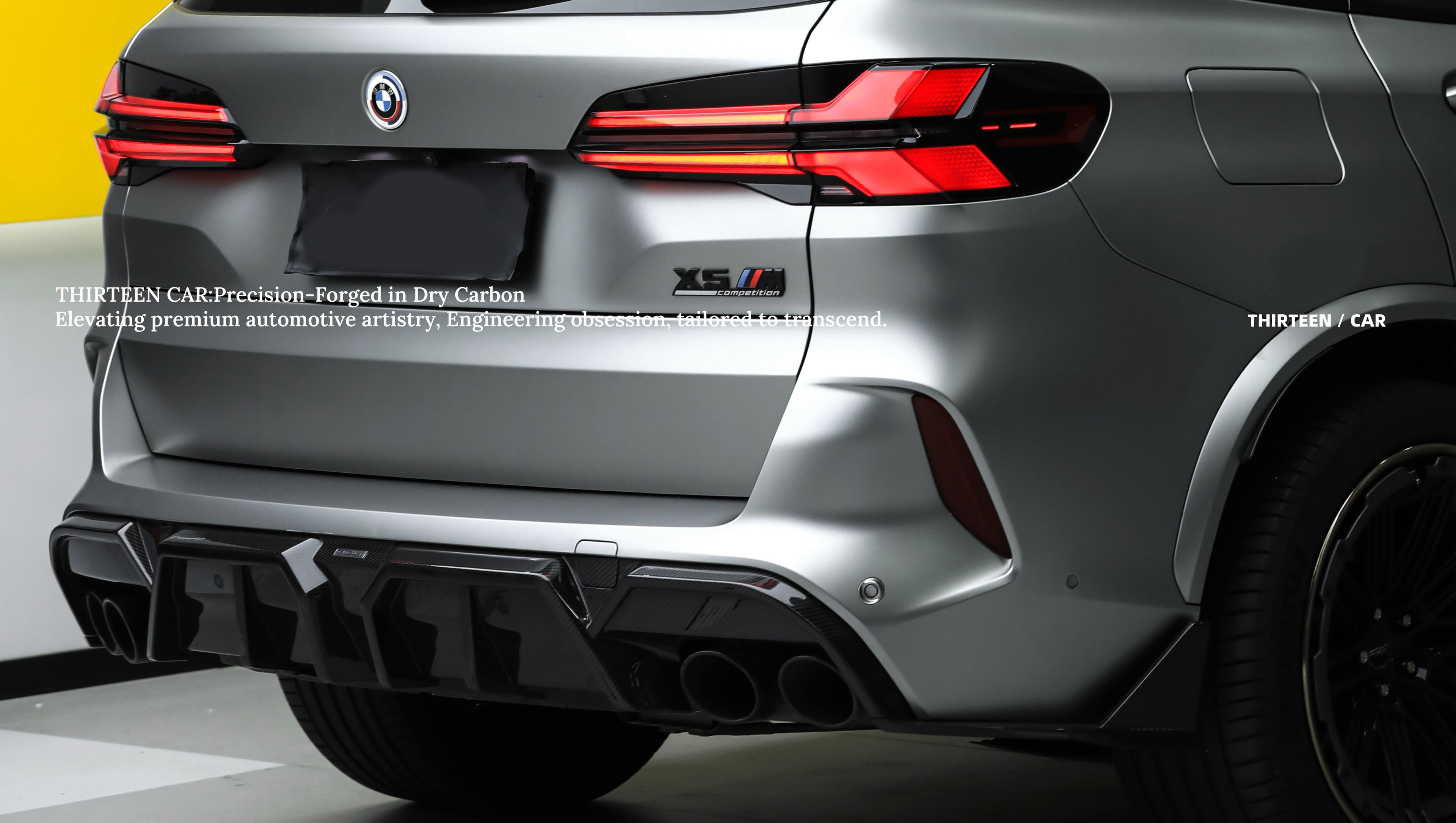 Front view of a white BMW X5M featuring a REVOZPORT carbon fiber hood, aggressive front bumper, enlarged air intakes, and carbon fiber front lip displayed inside a modern showroom.