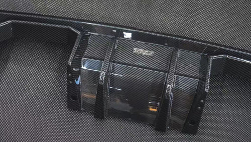 REVOZPORT glossy carbon fiber body kit components displayed before installation, including front lip sections, side skirts, rear diffuser, and aero trim pieces.
