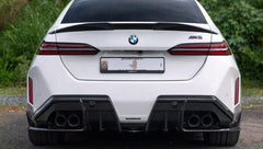 White BMW G90 M5 featuring a REVOZPORT carbon fiber front lip, side skirts, and aggressive front aero styling parked in a natural outdoor setting.