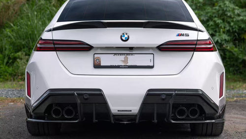 White BMW G90 M5 featuring a REVOZPORT carbon fiber front lip, side skirts, and aggressive front aero styling parked in a natural outdoor setting.