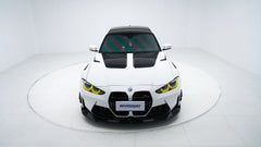 White BMW G80 M3 featuring a REVOZPORT carbon fiber body kit with front lip, side skirts, canards, vented fenders, and yellow DRL headlights displayed in a clean studio setting.