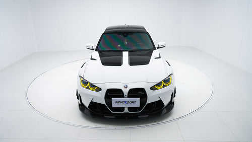 White BMW G80 M3 featuring a REVOZPORT carbon fiber body kit with front lip, side skirts, canards, vented fenders, and yellow DRL headlights displayed in a clean studio setting.