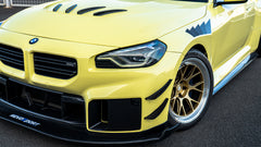 Close-up detail of a BMW front end featuring aggressive carbon fiber aero, vented hood, forged bronze wheels, and track-inspired styling.