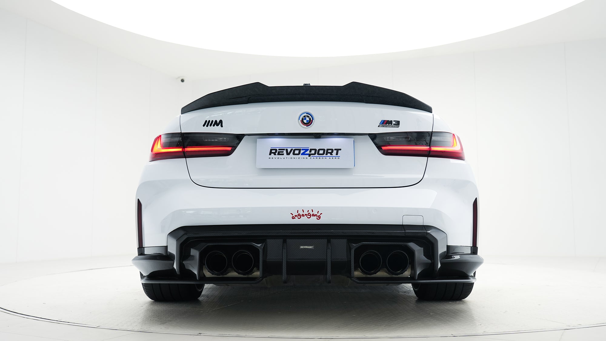 White BMW G80 M3 featuring a REVOZPORT carbon fiber body kit with front lip, side skirts, canards, vented fenders, and yellow DRL headlights displayed in a clean studio setting.