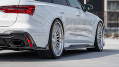 White Audi RS6 Avant featuring a REVOZPORT carbon fiber body kit with front lip, side skirts, rear diffuser, and lowered stance driving at high speed on a highway.
