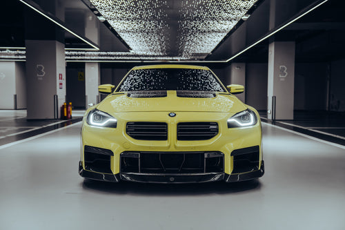 The BMW M2 is wrapped in carbon fiber, and in a high-end studio, the lights are turned on