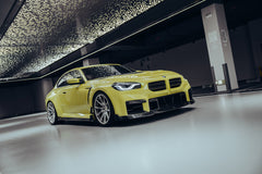 BMW with carbon fiber body kit parked outside a workshop, highlighting the aggressive front lip and side skirt design.