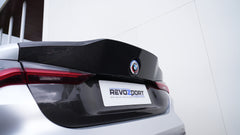 Close-up of a BMW G82 M4 rear end featuring a REVOZPORT carbon fiber trunk lid and integrated carbon rear spoiler, highlighting the glossy carbon weave detail.
